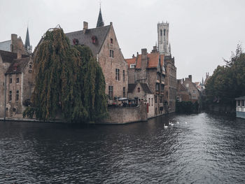 River amidst buildings in town against sky