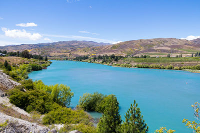 Scenic view of landscape and mountains against blue sky