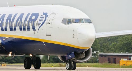 Close-up of airplane on airport runway against sky