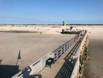 High angle view of pier at beach against blue sky