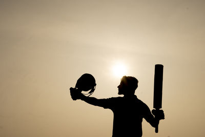 Rear view of man standing against sky during sunset