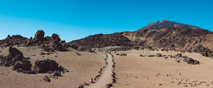 Scenic view of desert against clear blue sky