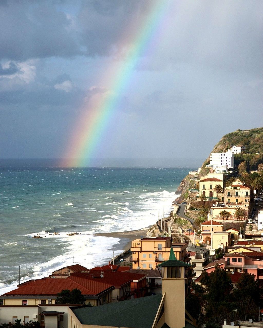 architecture, building exterior, built structure, rainbow, water, cloud - sky, sea, sky, beauty in nature, multi colored, nature, building, city, horizon, day, scenics - nature, horizon over water, residential district, outdoors, no people, double rainbow