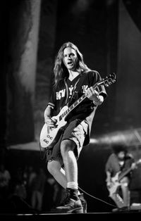 Young woman playing guitar at music concert