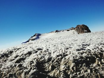 Low angle view of mountain against clear blue sky