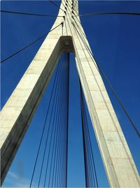 Low angle view of suspension bridge,. blue sky, white structure.