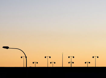 Silhouette street light against clear sky during sunset