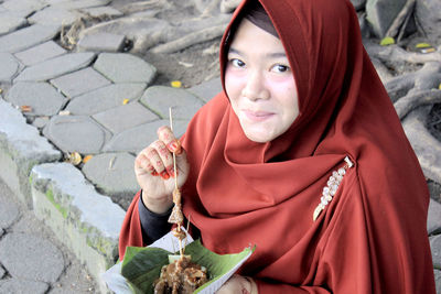 Portrait of young woman sitting outdoors