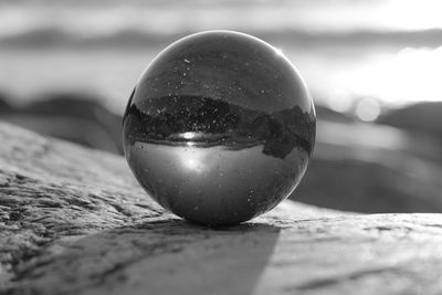 Close-up of crystal ball on rock outdoors