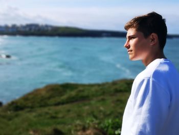 Side view of young man looking at sea