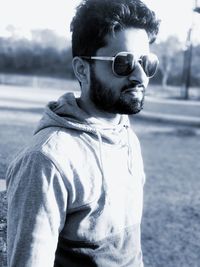 Young man in sunglasses standing on field