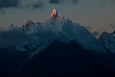 Scenic view of snowcapped mountains against sky during sunset