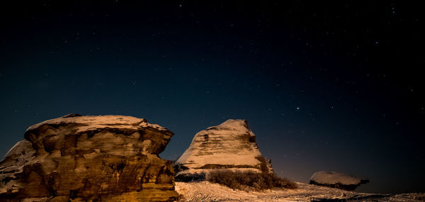 Low angle view of rock formation against clear sky at night