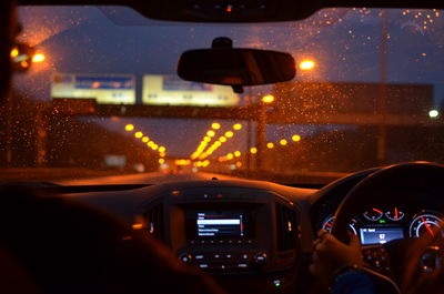 Cropped image of person driving car at night