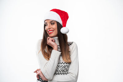 Portrait of smiling young woman standing against white background