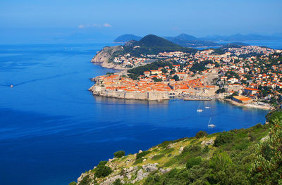 High angle view of sea and cityscape against sky