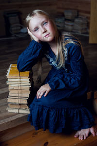 Portrait of girl with books sitting at home