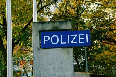 Close-up of road sign against trees