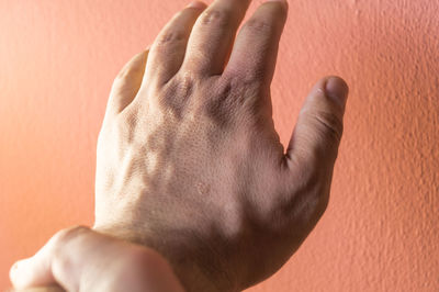 Close-up of hands against wall