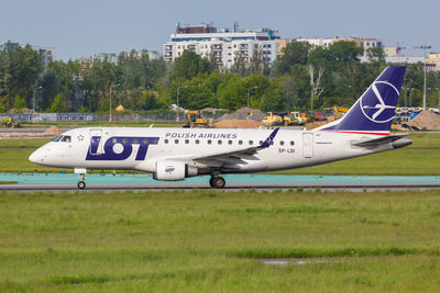 Side view of airplane on runway against sky