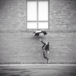 Young man walking on brick wall