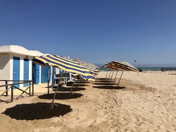 Lifeguard hut on beach against clear blue sky