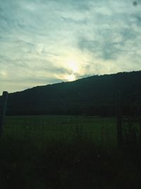 Scenic view of field against cloudy sky