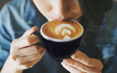 Midsection of woman holding coffee