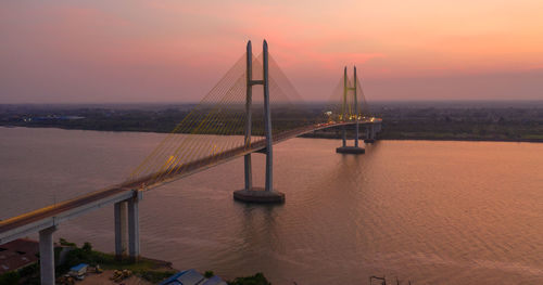 View of suspension bridge over sea during sunset