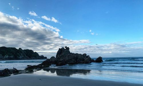 Rocks on beach against sky