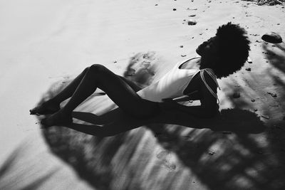 High angle view of woman lying down on beach 