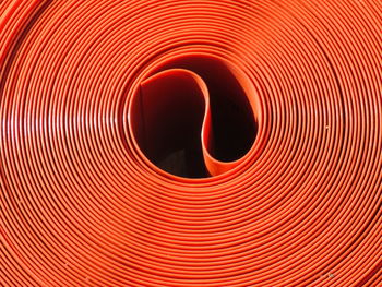 Full frame shot of rolled up orange pipes