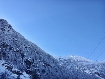 Scenic view of snowcapped mountains against blue sky