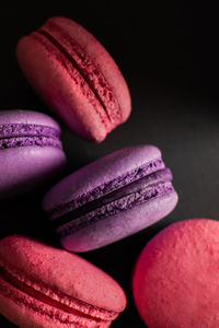 Pink and black macarons on dark background