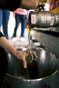 Close-up of hand bottling honey