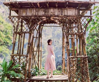 Woman standing against built structure