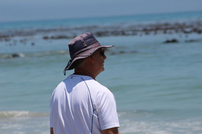 Rear view of man standing at beach