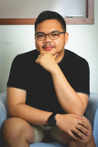 Portrait of young man sitting at home