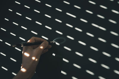 Cropped hand holding illuminated string lights