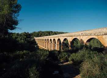 Arch bridge against clear blue sky