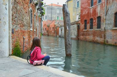 Woman sitting in canal