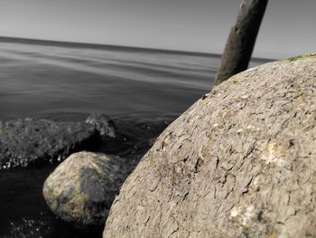 Close-up of rocks by sea against sky