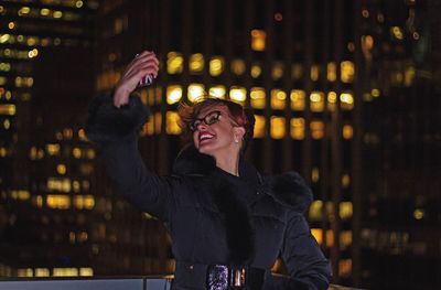 Portrait of smiling young woman in city