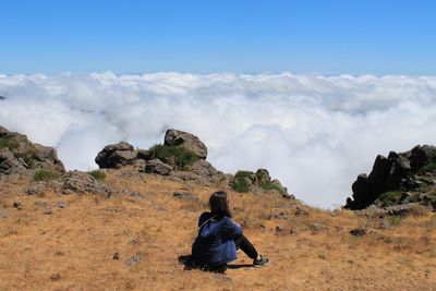 Rear view of woman sitting at pico do arieiro