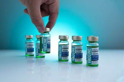 Close-up of hand holding coins over white background