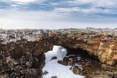 Coastline with atlantic ocean in cascais, portugal. waves at the shore and rocky hills