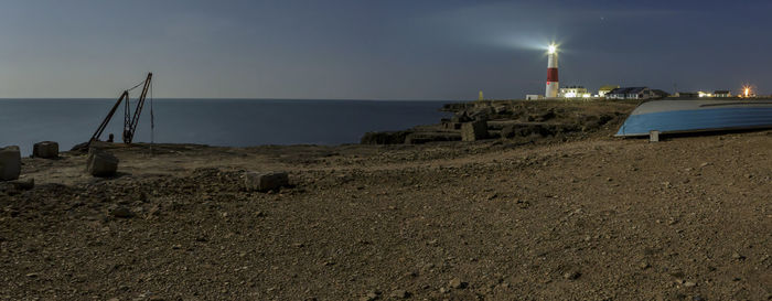 Lighthouse on beach at night