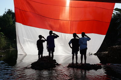 Rear view of people standing on boat