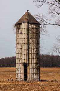 Old  silo on field against sky