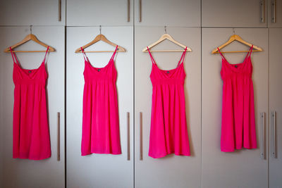 Pink dresses hanging on cupboards